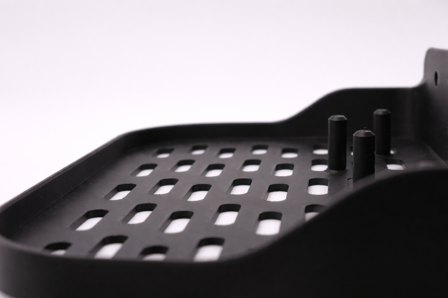 Perforated tray with cylindrical pegs.png