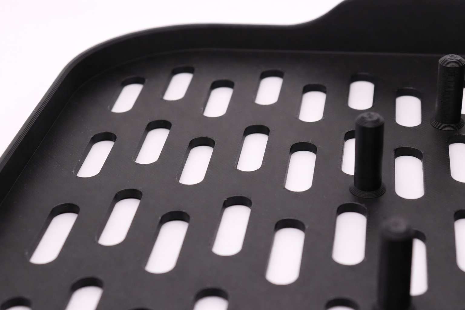 Black perforated tray close-up shot.png
