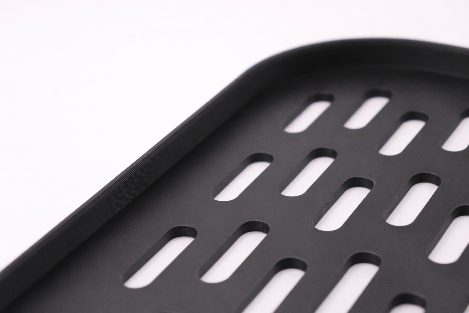 Perforated design of black tray corner.png