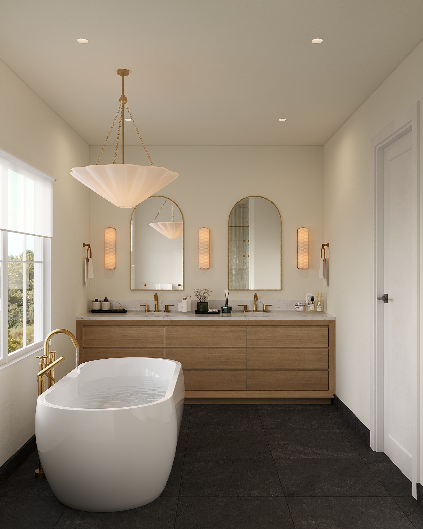 Modern bathroom with a large oval bathtub, dark tile flooring, a wooden vanity with a marble countertop, three mirrors, two wall-mounted lights, and a window with a view of trees outside.