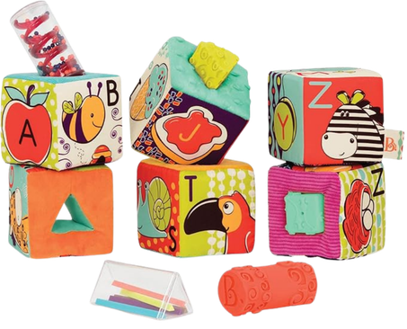 Colorful soft toy blocks with animal and alphabet designs, plus a small plastic stacking ring and a tongue depressor.