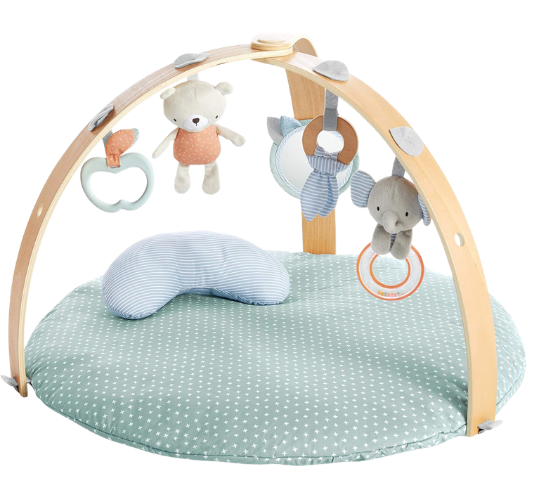 Baby play gym with soft toys hanging from a wooden arch and a cushioned mat with a star pattern.