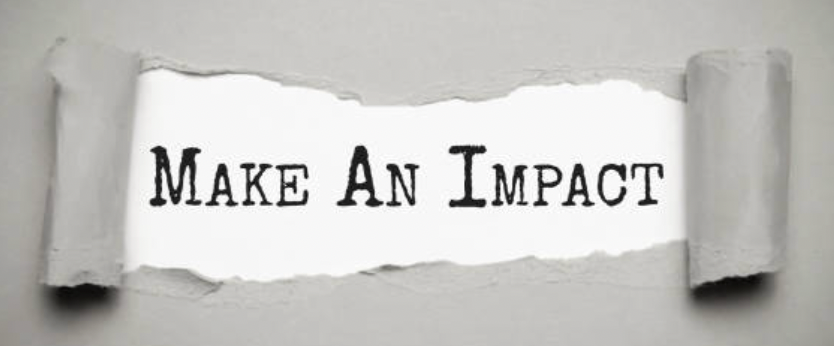 A torn piece of paper with the words "Make An Impact" written on it, attached to a light gray wall.