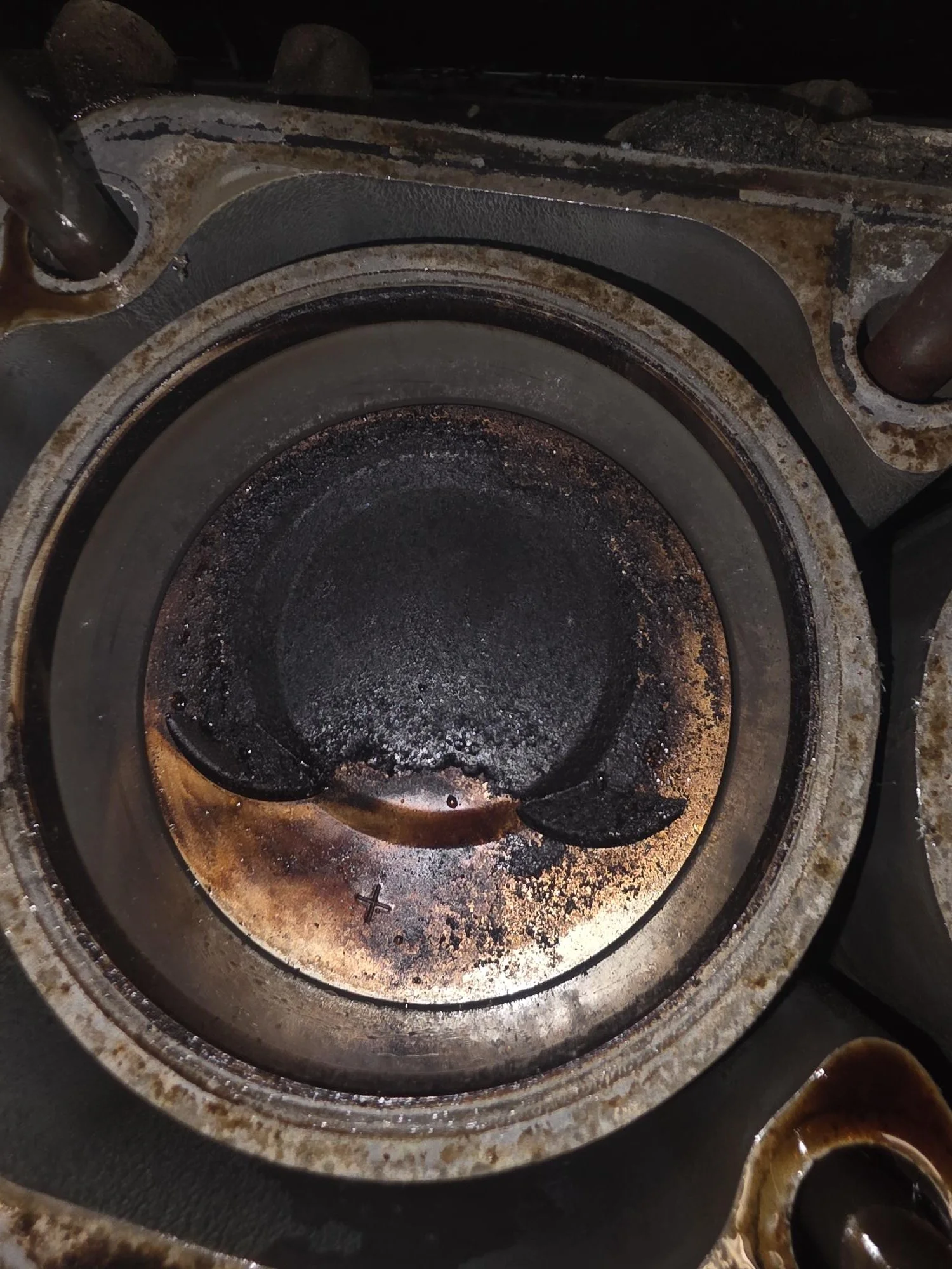 Porsche 944 2.5L Alusil piston crown exhibiting extreme carbon loading; diagnostic evidence of total valve stem seal failure in Bend, Oregon.