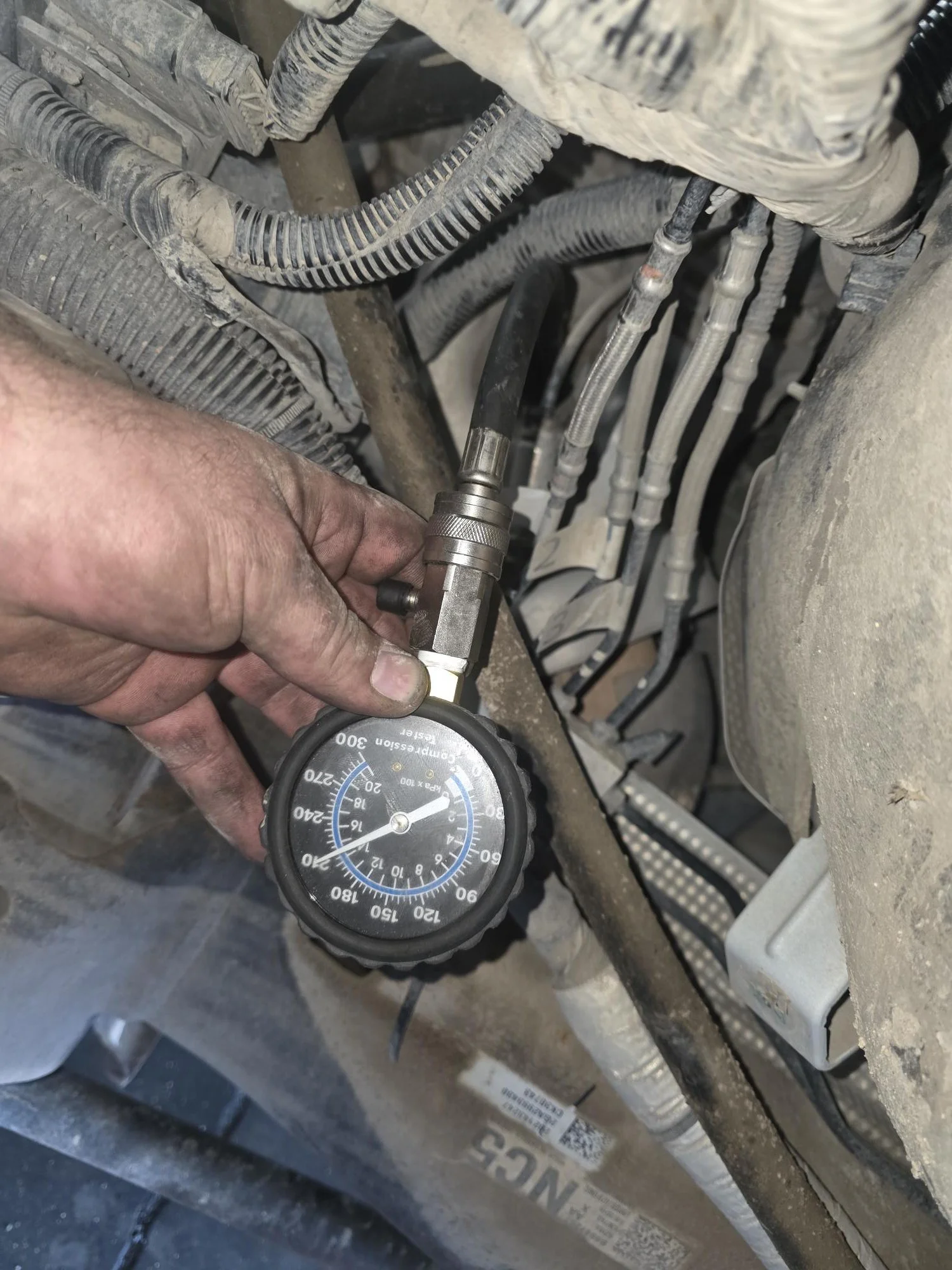 Forensic compression testing on a GM 6.6L L8T engine; documenting individual cylinder PSI to verify internal mechanical health and ring seal during a comprehensive buyer's inspection.