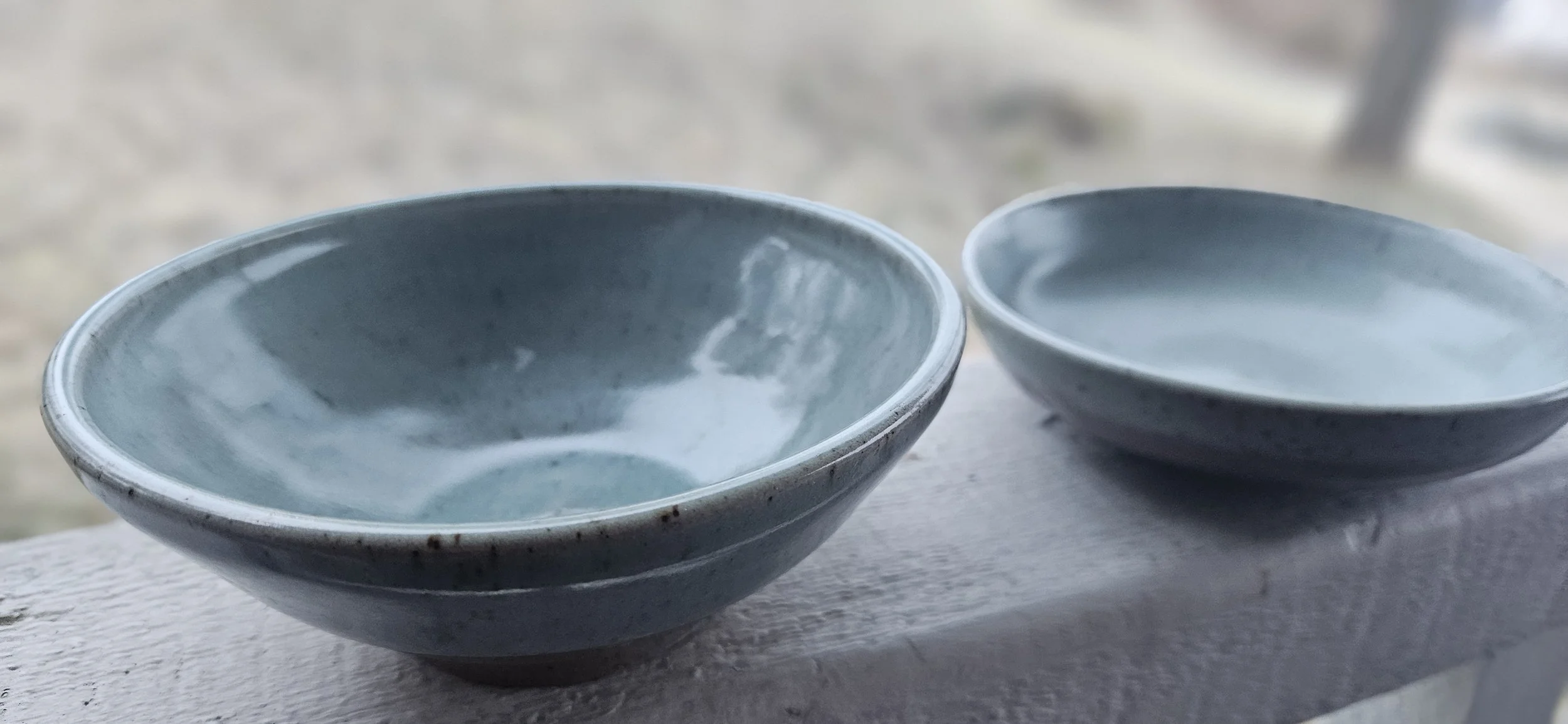 Two blue ceramic bowls with glossy interiors placed on a white surface.