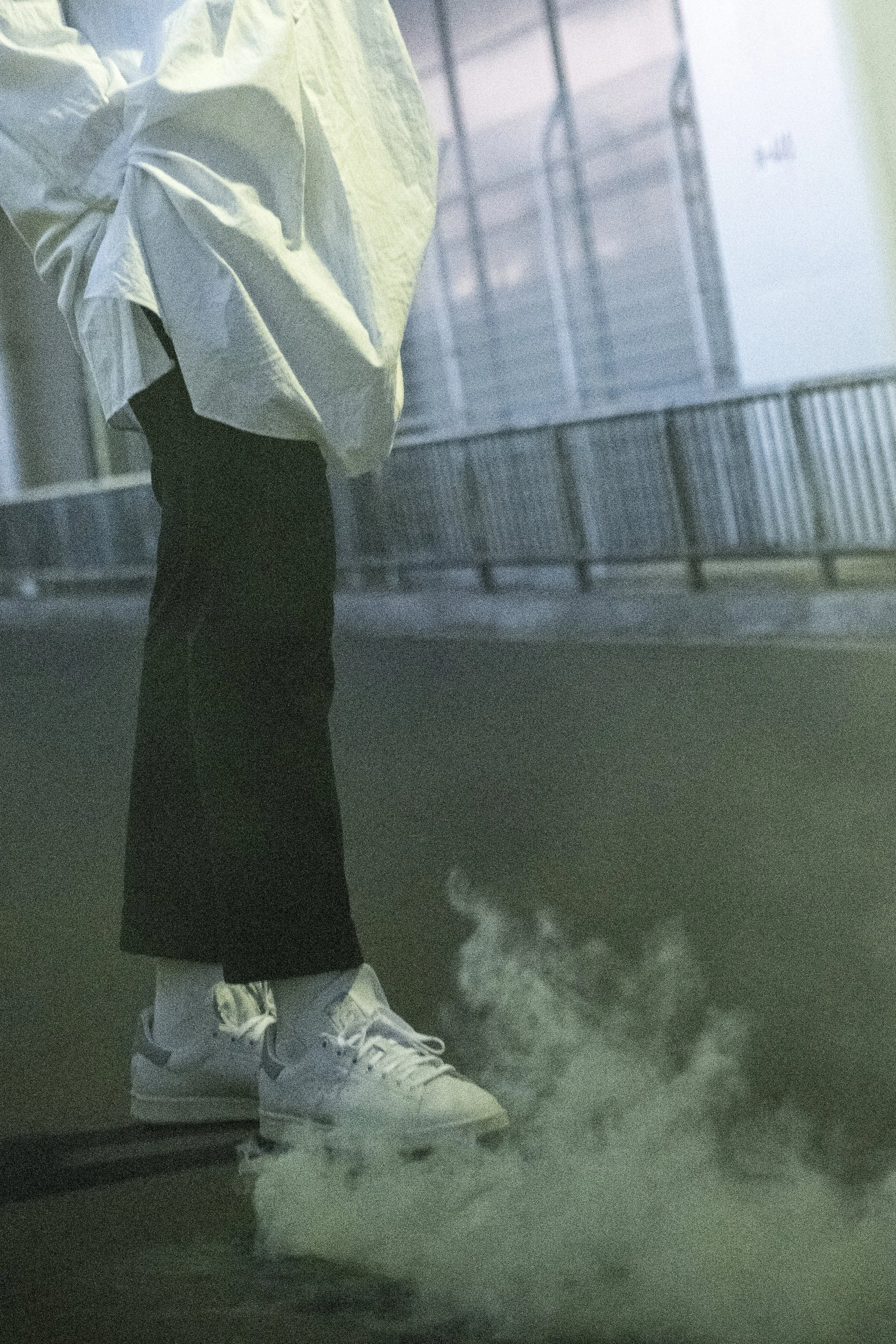 Lookbook image of a model standing on a city street at night.