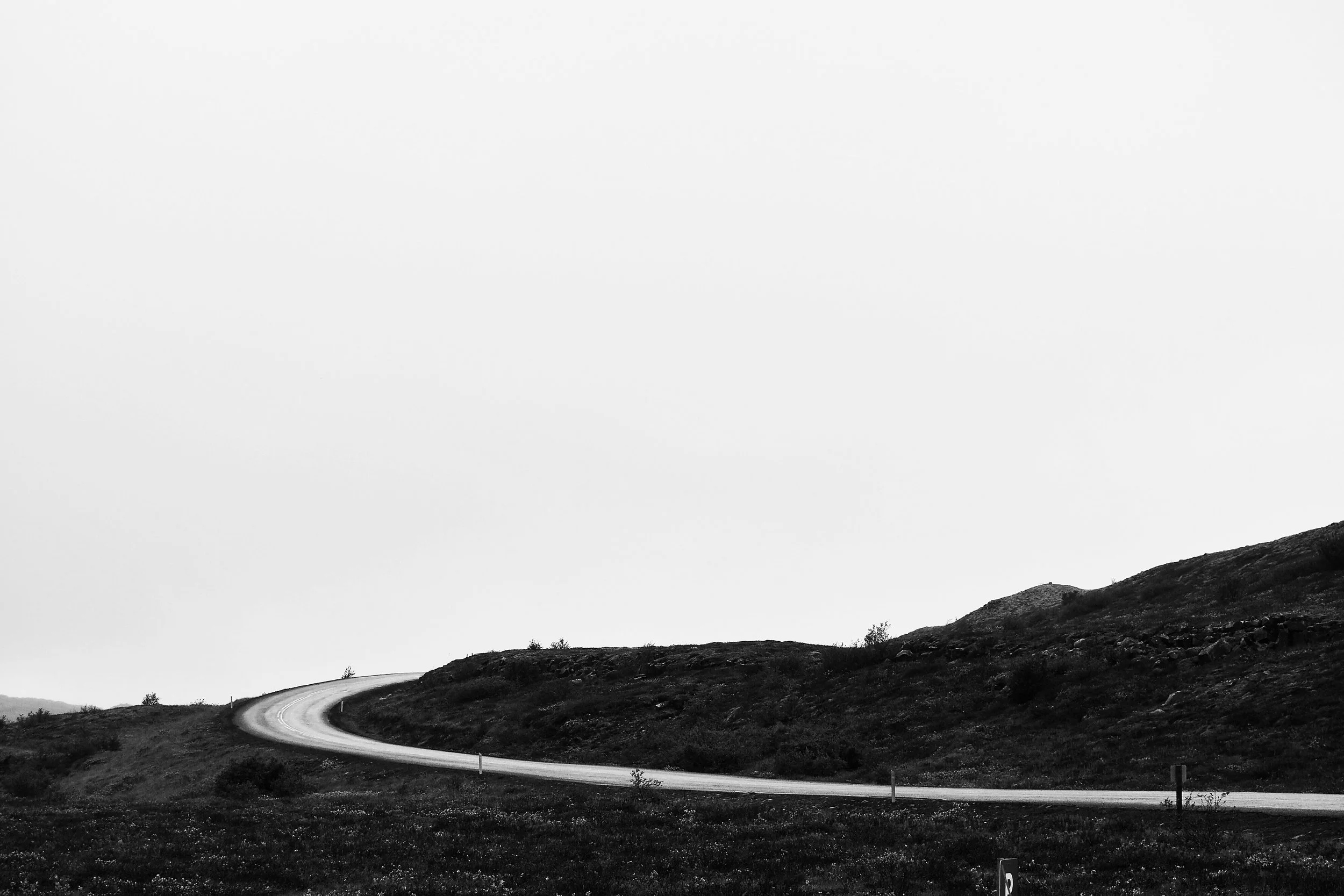 Gullfoss, Iceland: Black and white photo of a winding road going through hills and open landscape