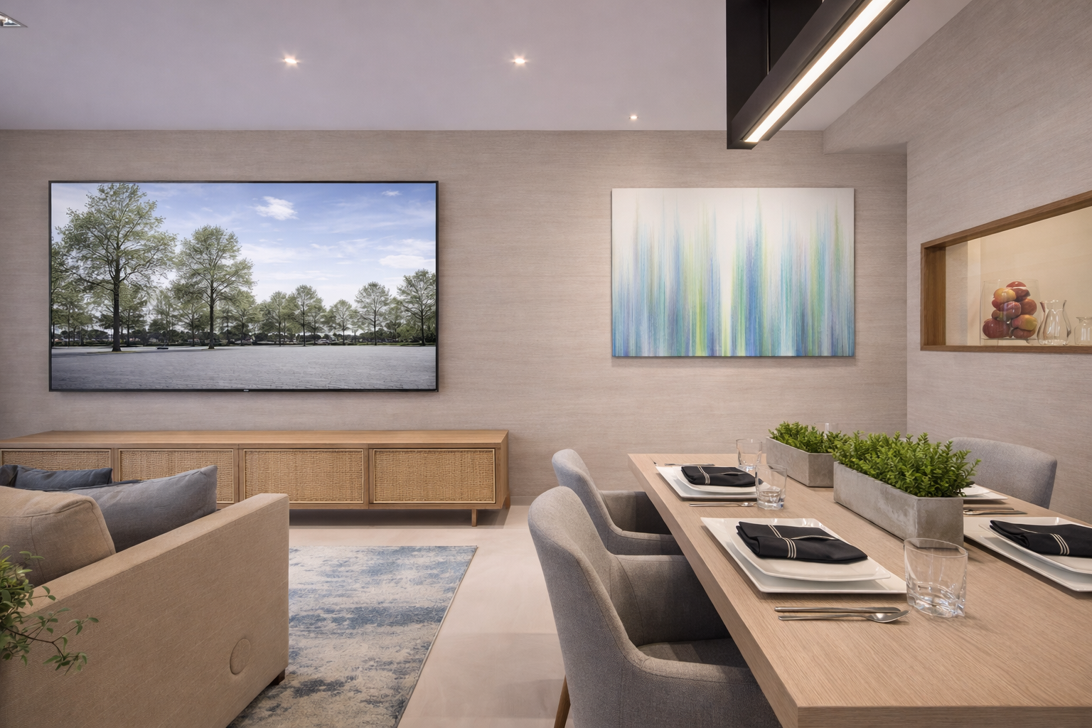 Modern dining room and living area with a large wall-mounted TV, a wooden sideboard, abstract artwork, a dining table set with black napkins, place settings, glasses, and two planters with green plants, and a beige sofa with cushions.