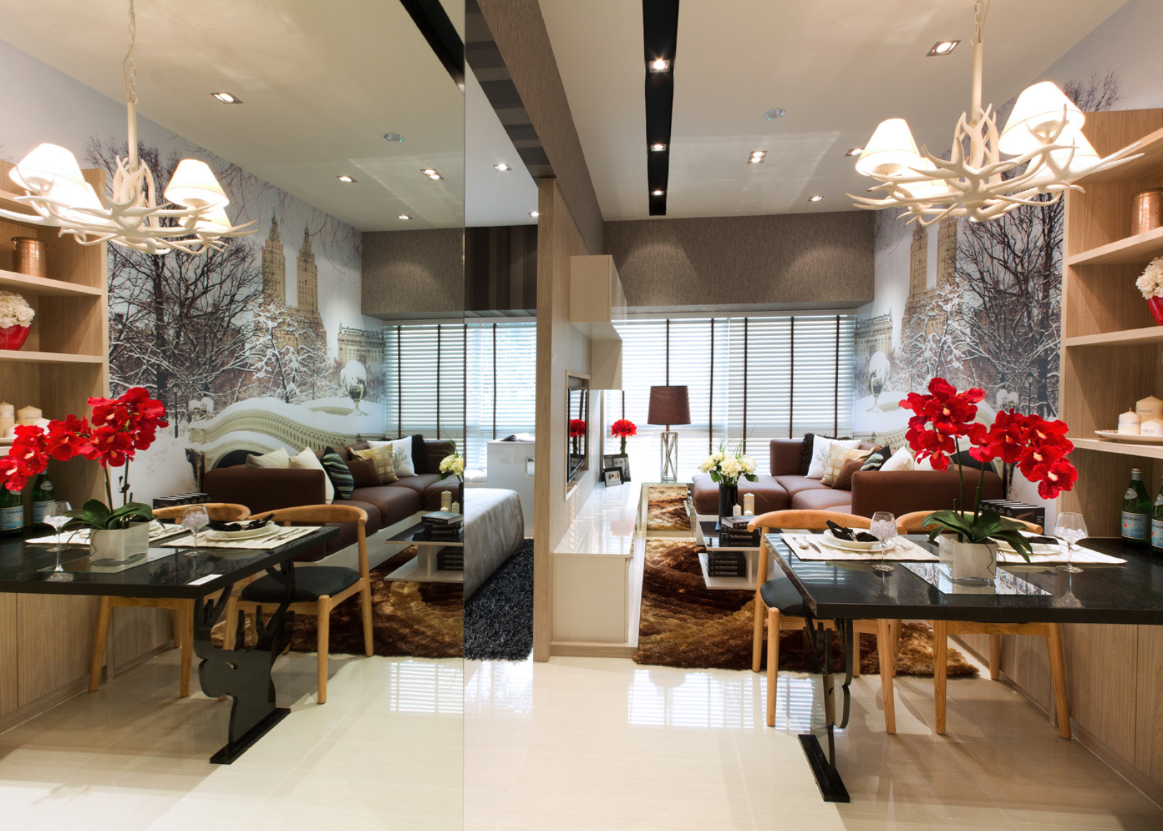 Living room with brown sofas, white wall with winter cityscape mural, large windows with blinds, multiple tables with flowers and decor, chandelier, and colorful area rugs.