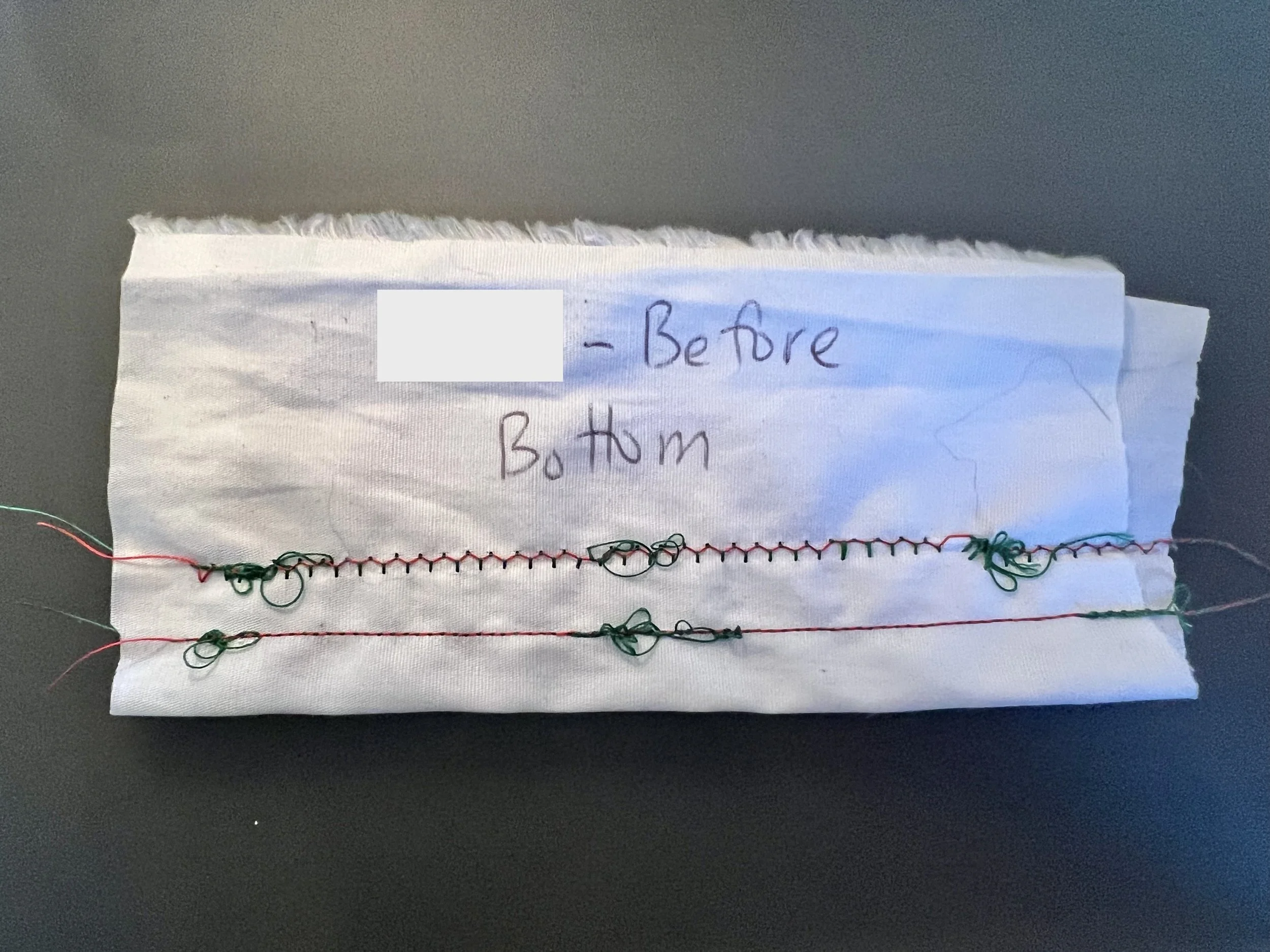 White quilting cotton sewn with red and green threads. The green thread is looped and snarled. The fabric is labeled Before: Bottom