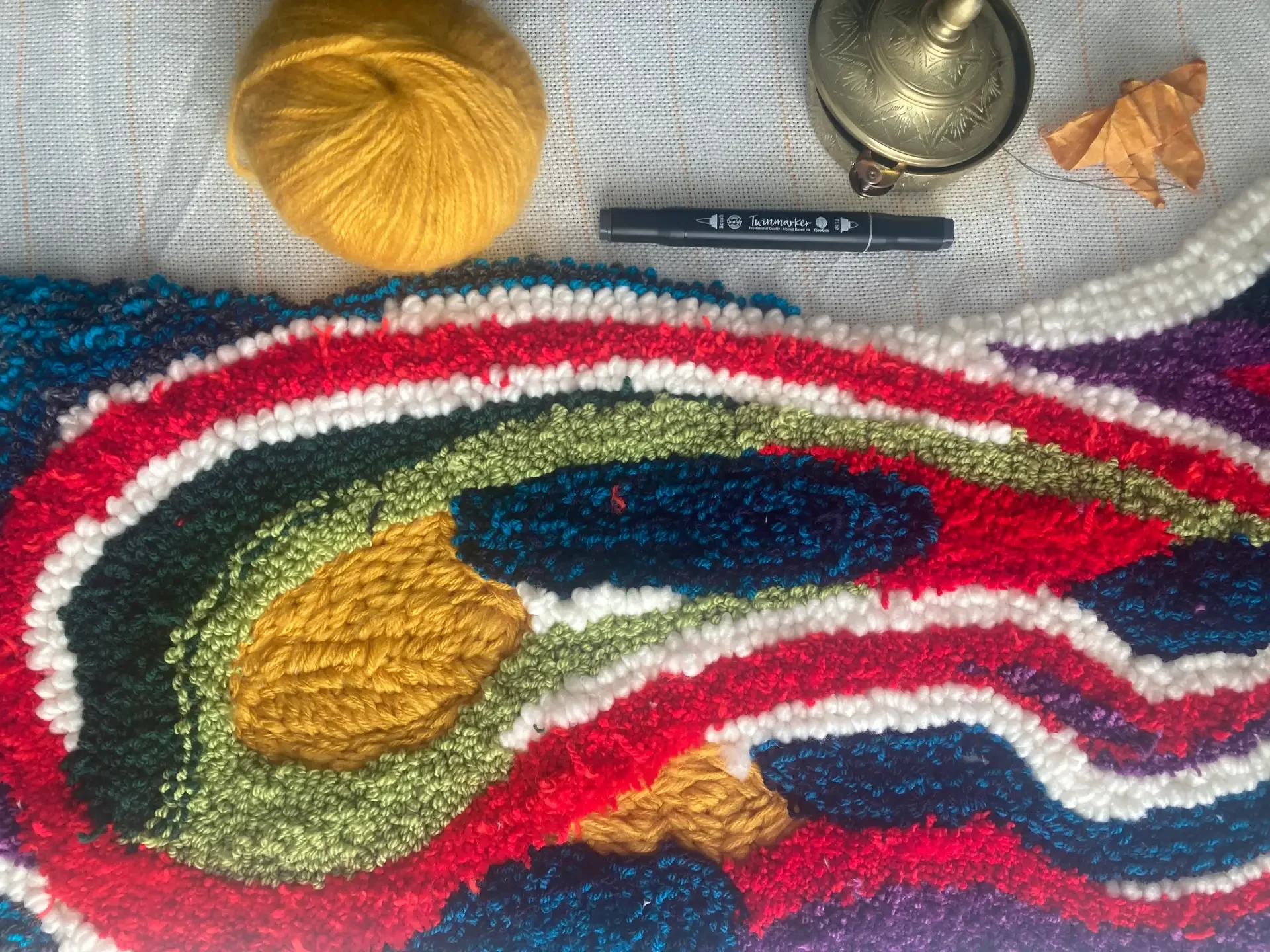 Laine colorée tressée, marqueur, aiguilles et matériel créatif pour la création du tapis mural de la Maison et Atelier Ama Adao créé par Chloé Fortunet. 