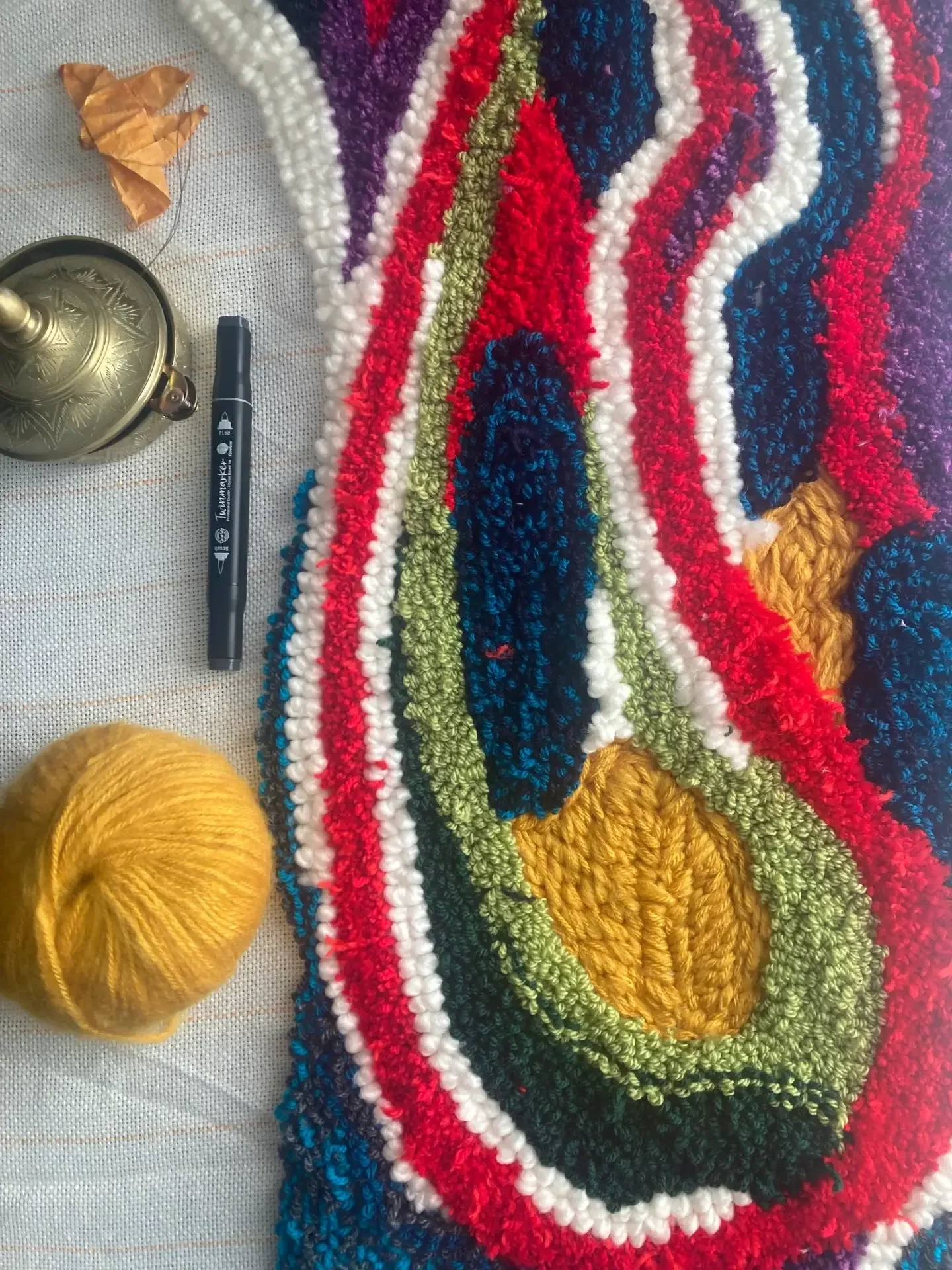 Laine colorée tressée, marqueur, aiguilles et matériel créatif pour la création du tapis mural de la Maison et Atelier Ama Adao créé par Chloé Fortunet. 