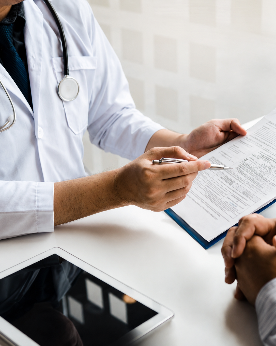 Clinician holding a clipboard while speaking with a patient
