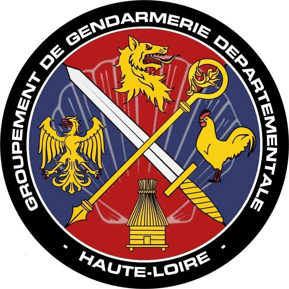 Logo de la Gendarmerie de l'époque de la Haute-Loire avec un lion, un aigle, un coq, une épée, une batteuse et une selle, entouré du texte 'GROUPEMENT DE GENDARMERIE DE L'ARDEENTALE - HAUTE-LOIRE'.