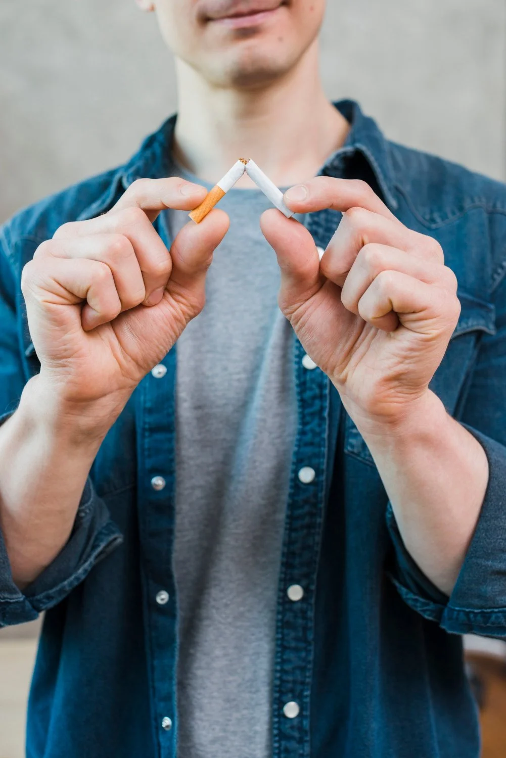 Une personne qui tient deux cigarettes brisées en forme de cœur.