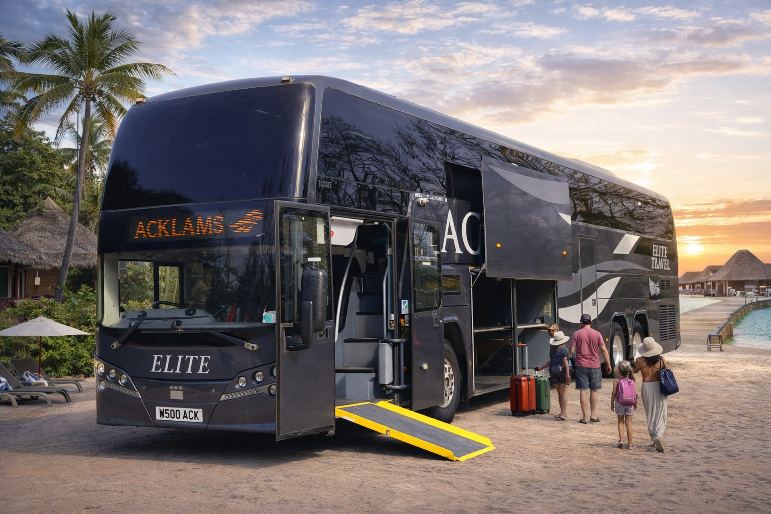 Large black luxury tour bus labeled 'Elite Travel' and 'Elite' with a mobile ramp extended for passengers, parked near tropical resort with palm trees, thatch-roof huts, lounge chairs, and a pool during sunset. People with luggage are walking toward the bus.