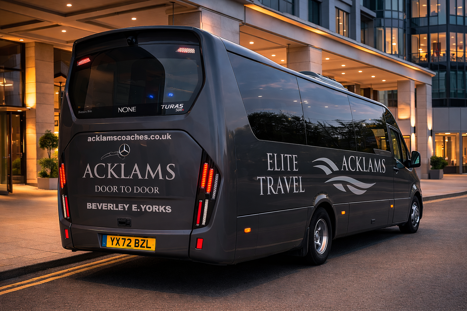 A black luxury van parked outside a modern building during evening, with company logos and contact information displayed on the side and back.