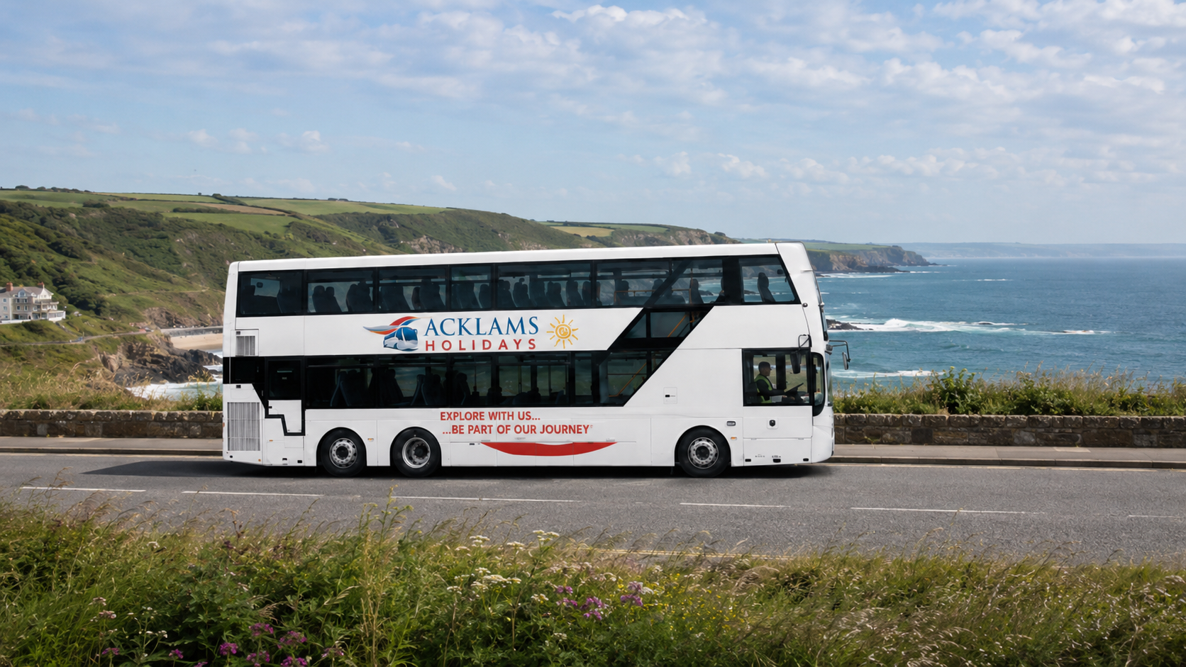 98 seat Double-decker bus with 'Acklams Holidays' logo traveling along a coastal road with cliffs, greenery, and ocean in the background on a partly cloudy day.