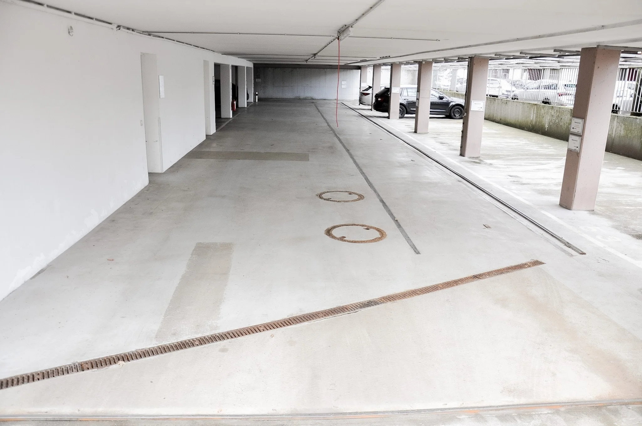 Leerer Parkhaus-Einfahrtsbereich mit Parkplätzen und automatischer Schranke