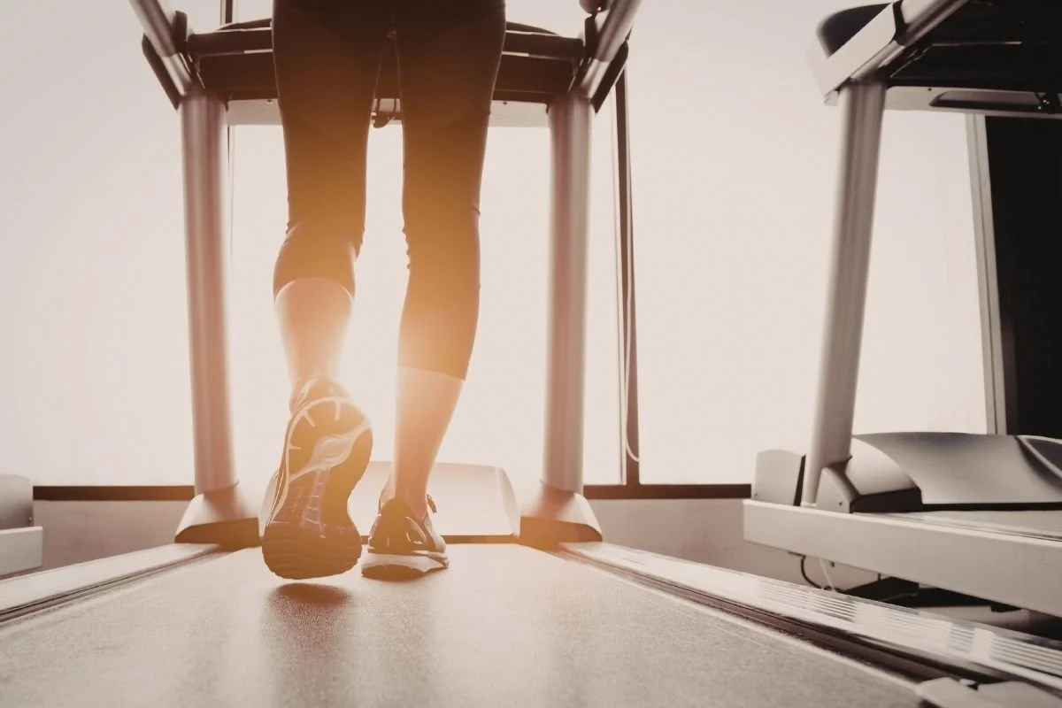 Person running on a treadmill showing foot and leg movement, representing podiatry and biomechanics