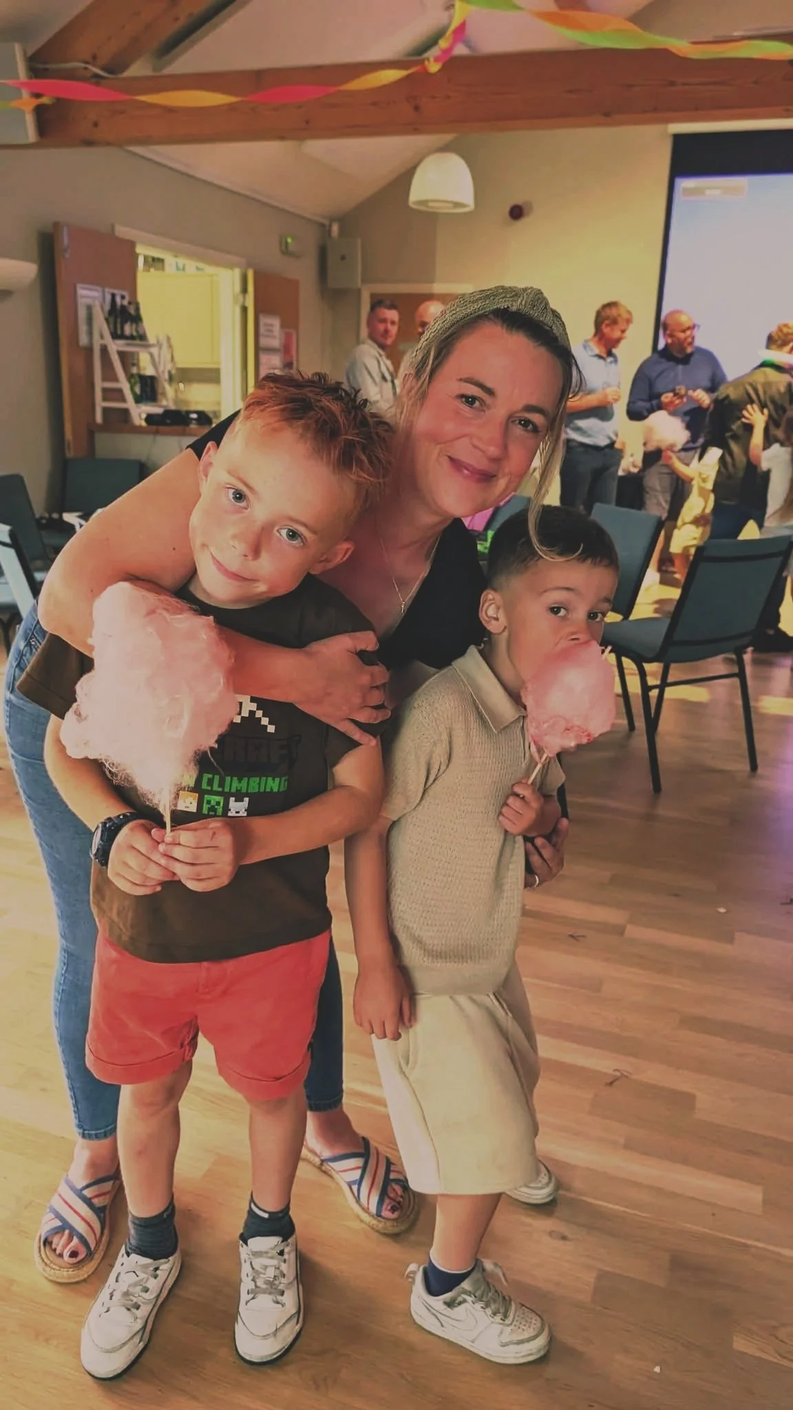 Mother with two young boys enjoying a family celebration indoors.