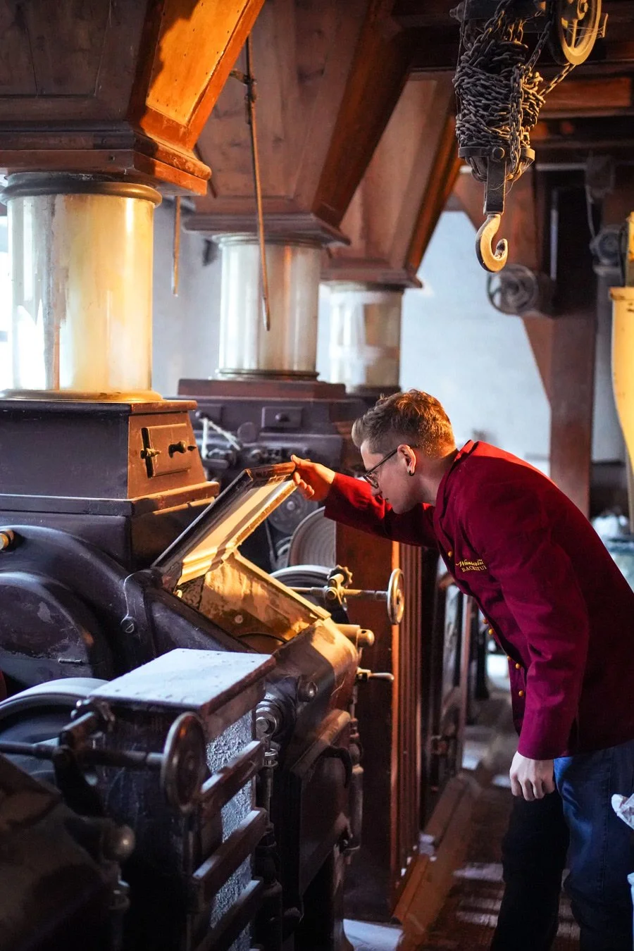Markenkampagne Wunderlichs Backstuben - junger Bäcker blickt in die Mahlmaschiene in der Produktion - authentische Handwerksfotografie - Culet