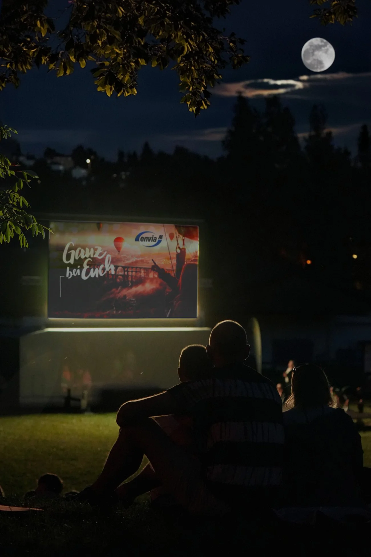 Sponsoring Sommernachtskino - Silhouette einer Familie vor beleuchteter Leinwand im Vollmond - Markenfotografie Culet