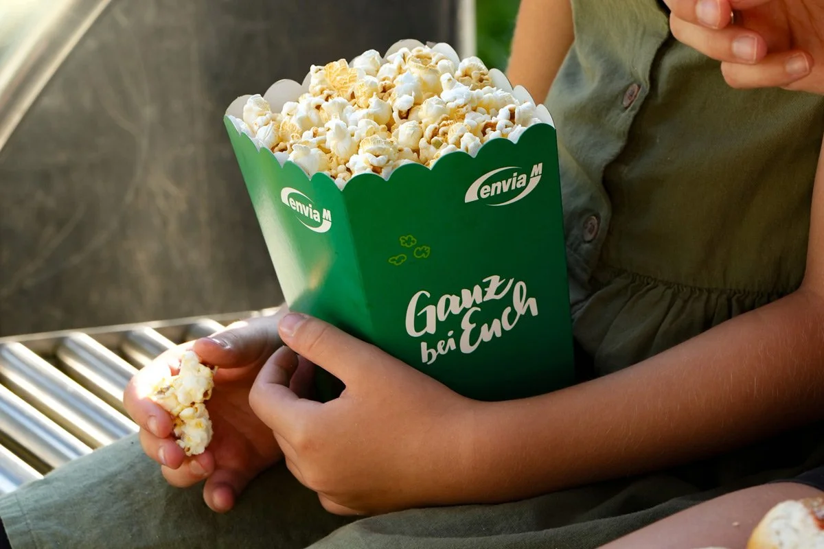 Sponsoring Sommernachtskino - Detailaufnahme Popcorntüte mit Markenlogo in Kinderhänden - Markenfotografie Culet