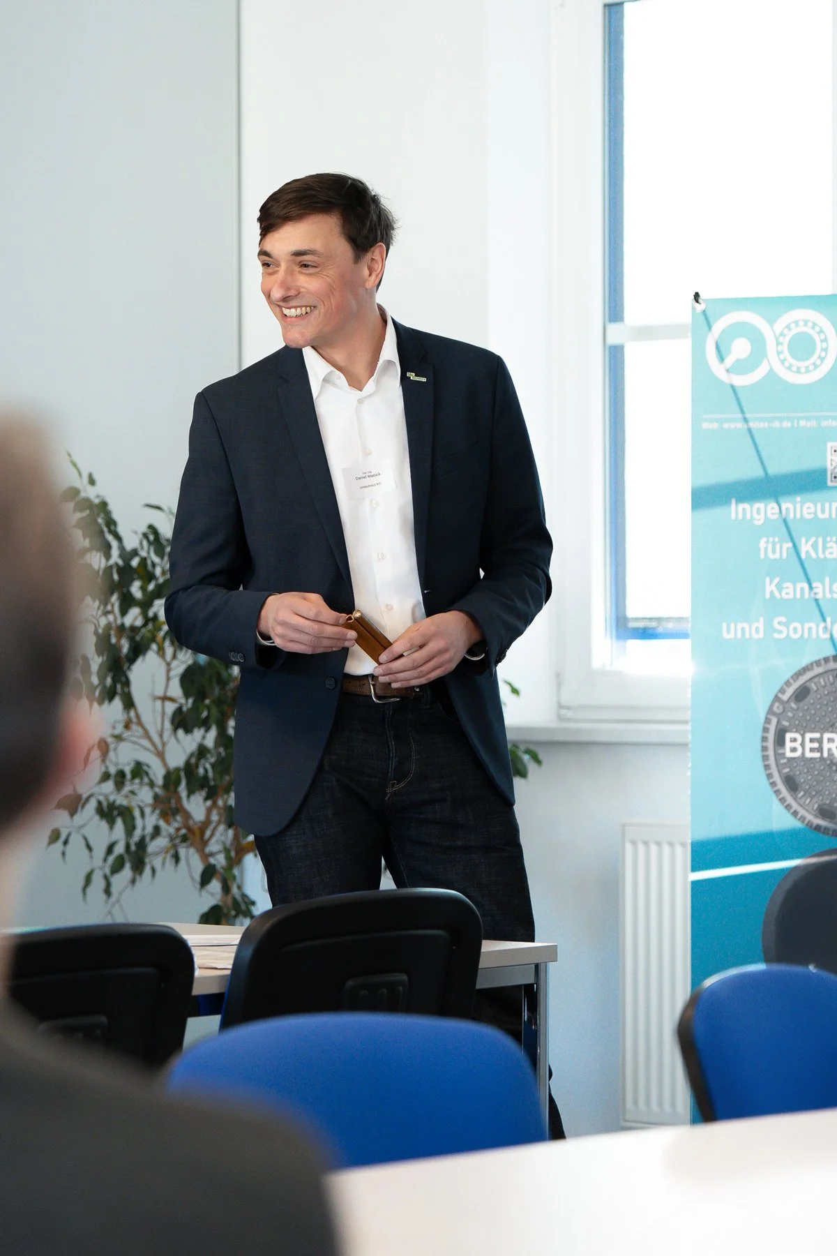 Geschftsführer lächelt während einer Seminarpräsentation - dokumentarische Businessfotografie von Culet