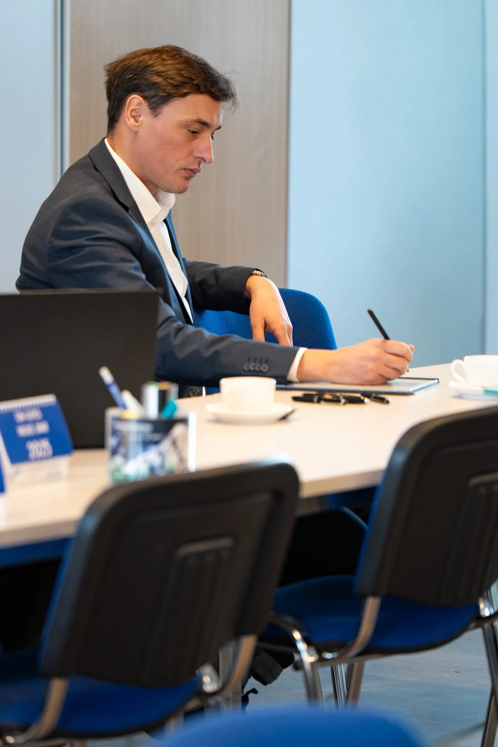 Authentische Businessfotografie: Mann am Schreibtisch bei konzentrierter Arbeit-dokumentarischer Moment statt gestellter Posekonzentriertes Arbeiten, dokumentarischer Moment statt gestellter Posen - Businessfotografie von Culet