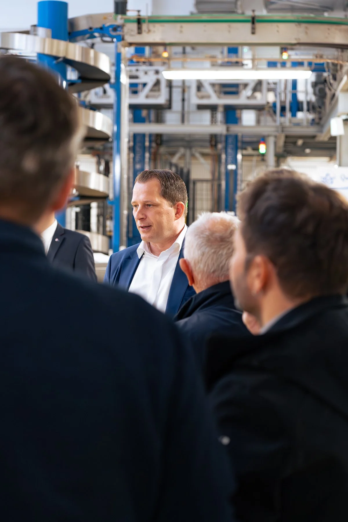Geschäftsführer erklärt Produktionsabläufe in einer Industriehalle- Businessfotografie im echten Arbeitsumfeld - authentische Businessfotografie von Culet