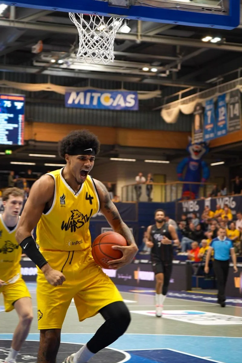 Livefotografie ENBL Basketball - Spieler jubelt nach Korbwurf, Vereinslogo im Hintergrund - Livefotografie Culet