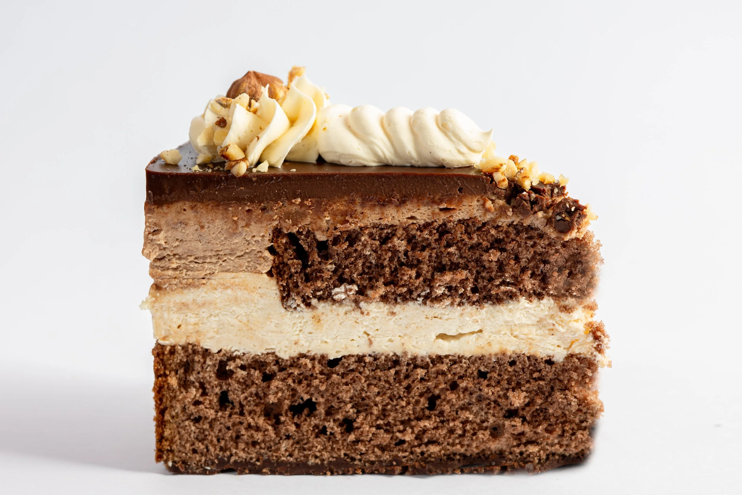 Mehrschichtige Schokoladentorte mit weißer Creme und Nüssen