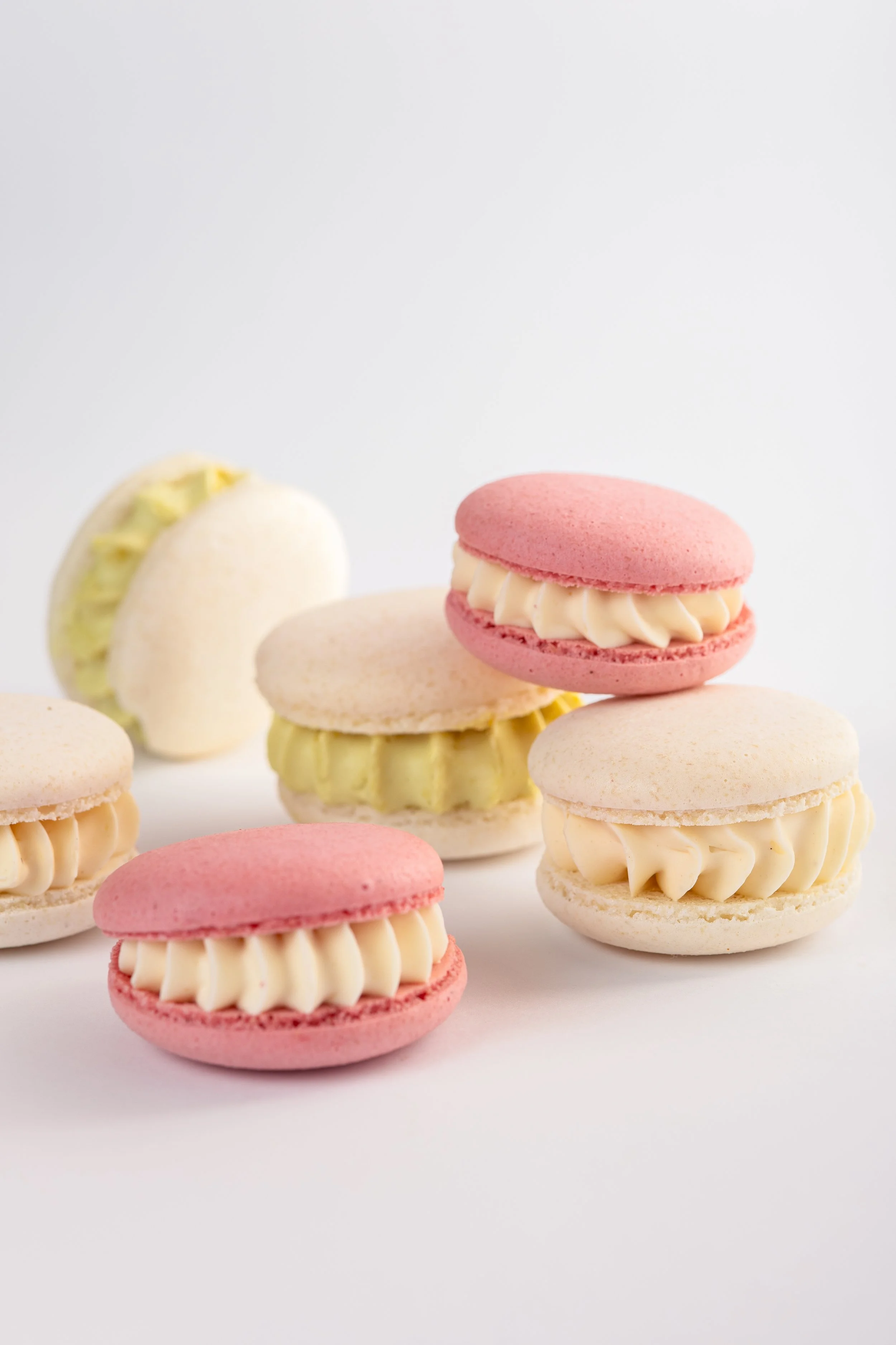 Bunte französische Makronen mit cremiger Füllung auf weißem Hintergrund.