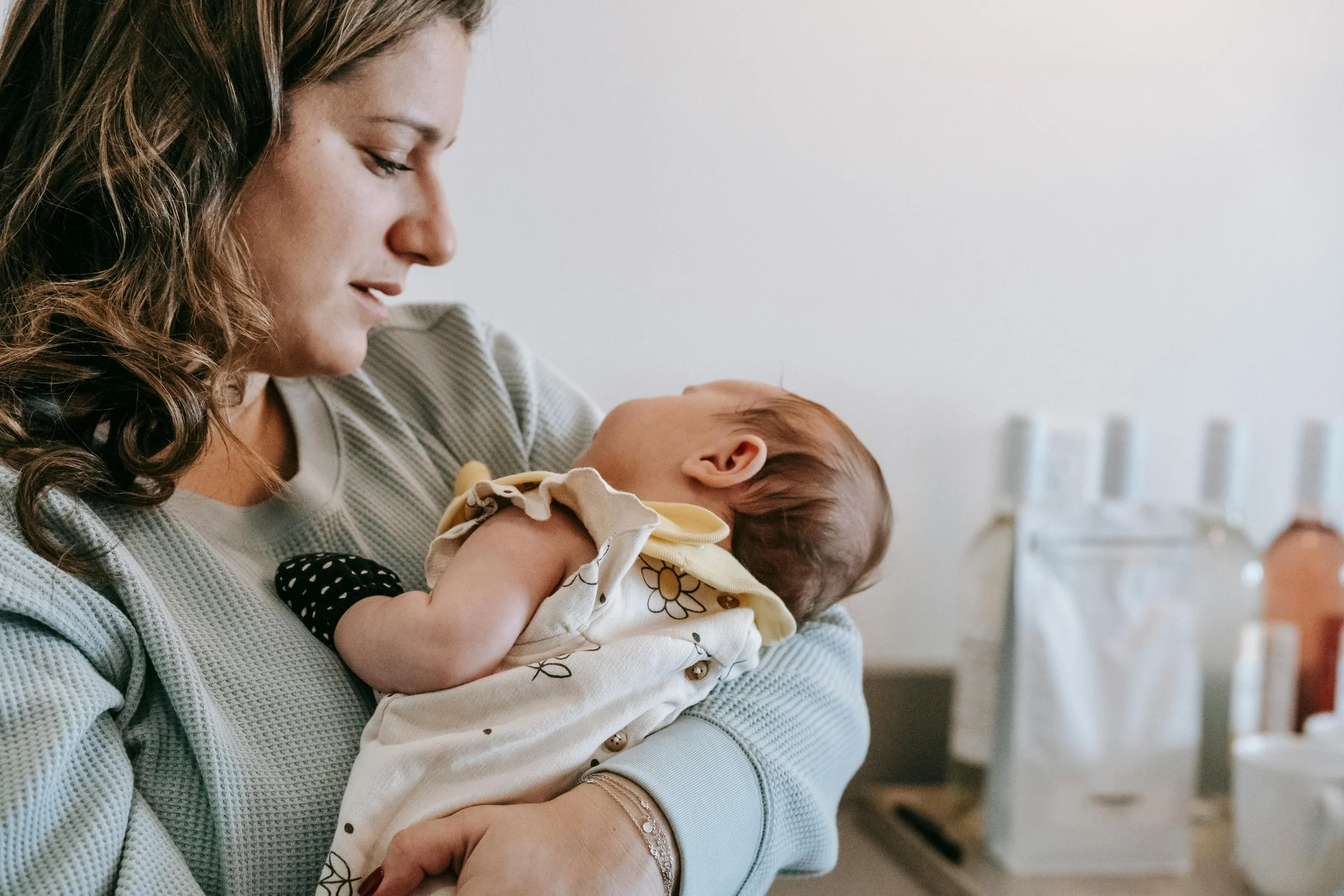 Mom and newborn snuggling together because Strong Roots Occupational Therapy provides in-home maternal health and infant occupational therapy services in the southern New Jersey and Philadelphia areas