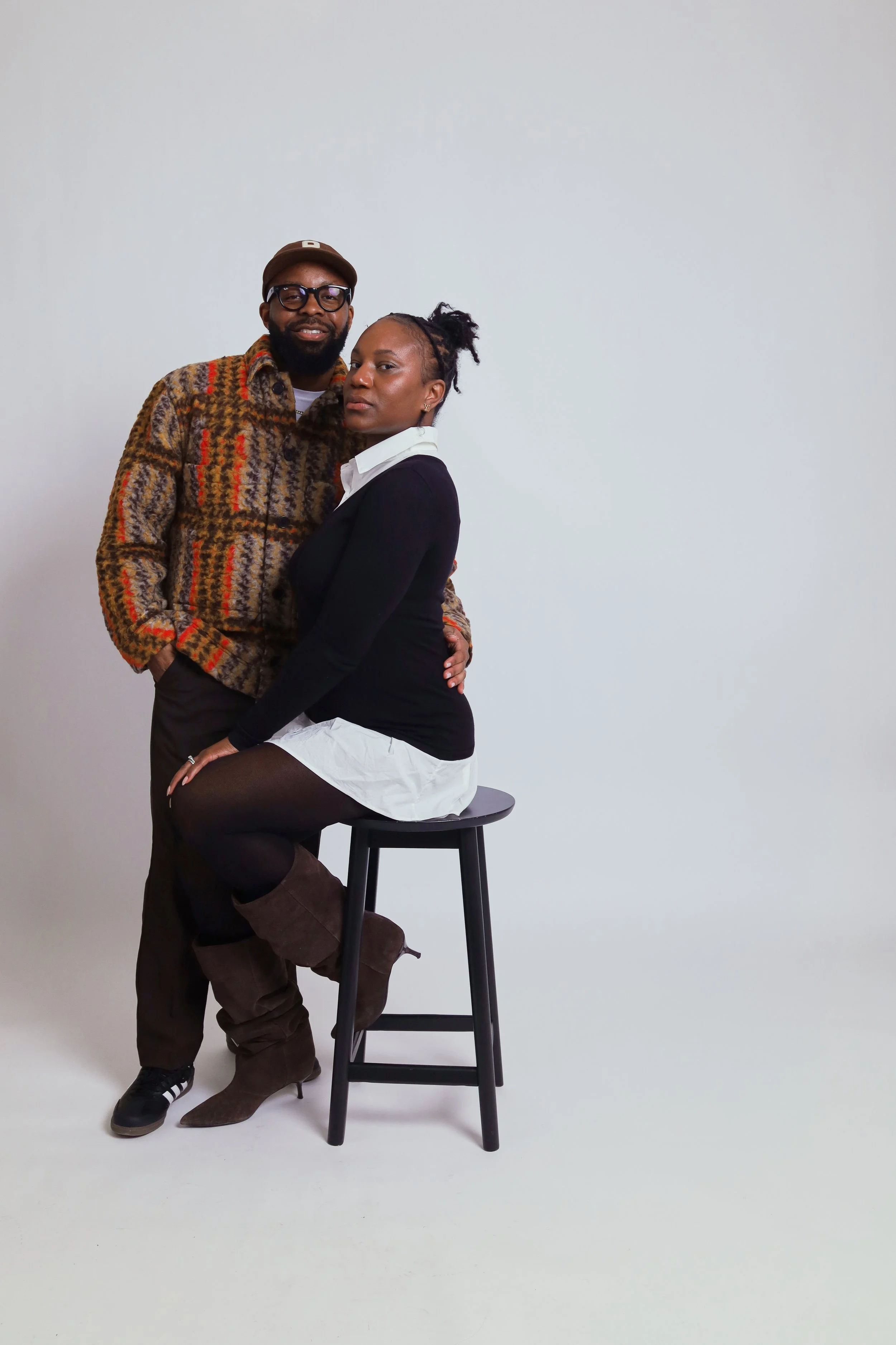Couple posing at a studio and sitting in chair to resemble headshot photography