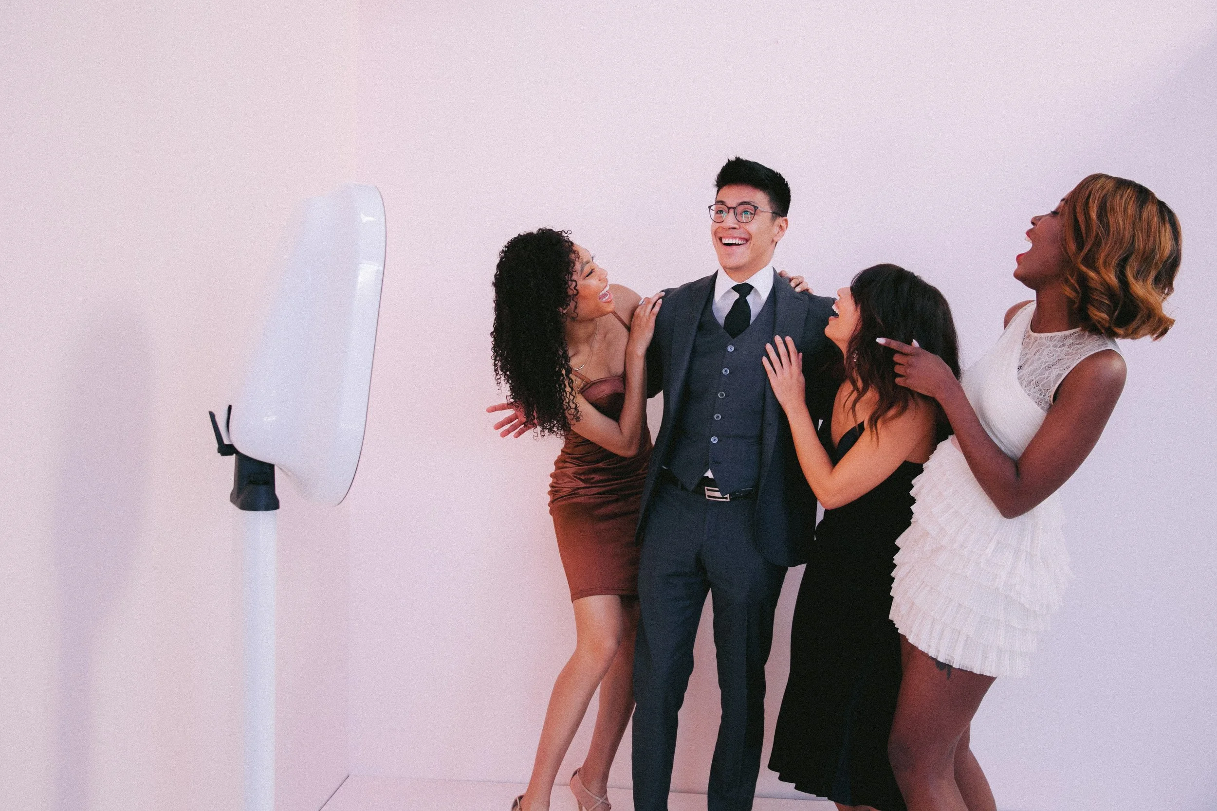 Guest posing at a selfie style photobooth that is open air with smiles and laughter