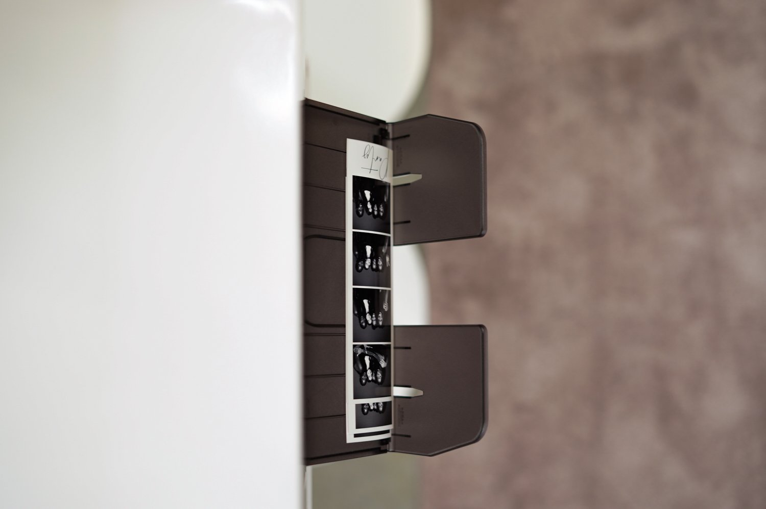 Black and white 2x6 classic strip prints with a minimal white printer stand