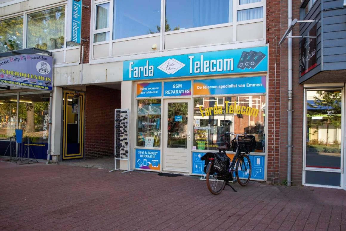 Exterior of Farda Telecom store with blue signage, a bicycle parked outside, and neighboring storefronts.