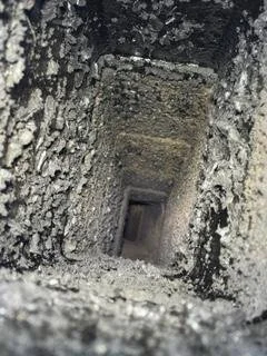 Looking down a narrow, dirty chimney that needs to be cleaned by Silas Miller Stove & Chimney
