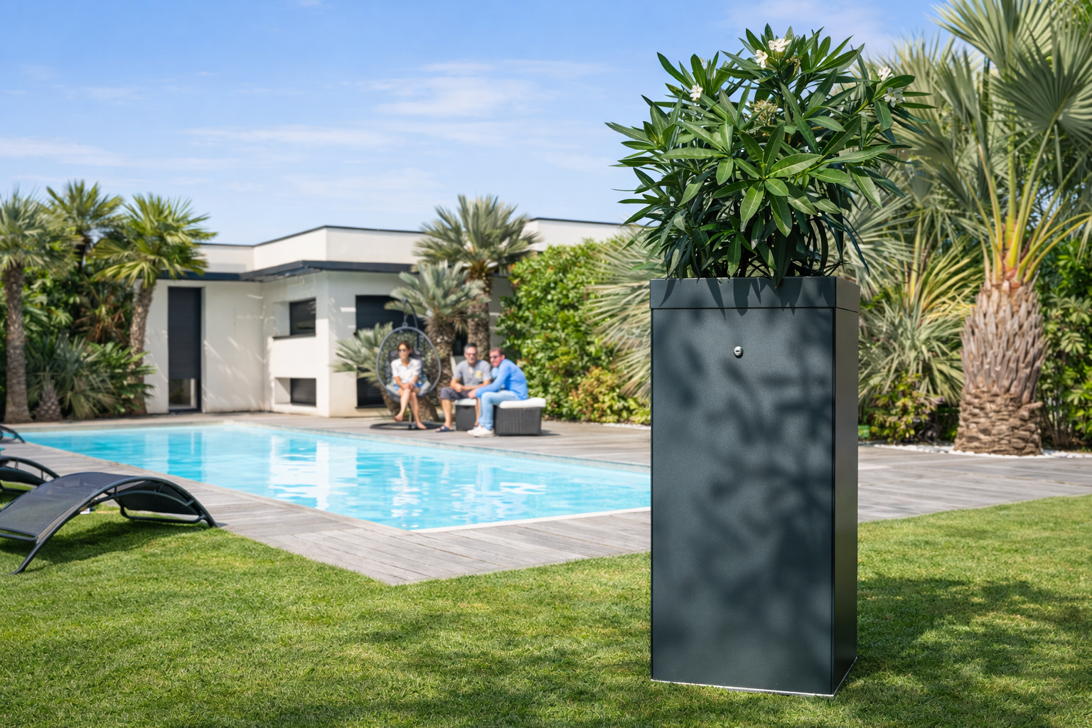 Jardín con piscina, lujosa casa moderna, sofá de exterior y personas relax. Maceta con planta y cielo despejado.