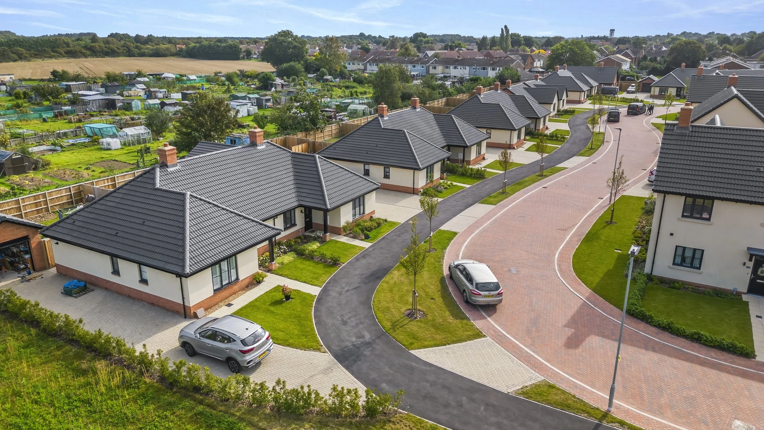 Curving residential street with mixed-tenure homes at The Lilacs