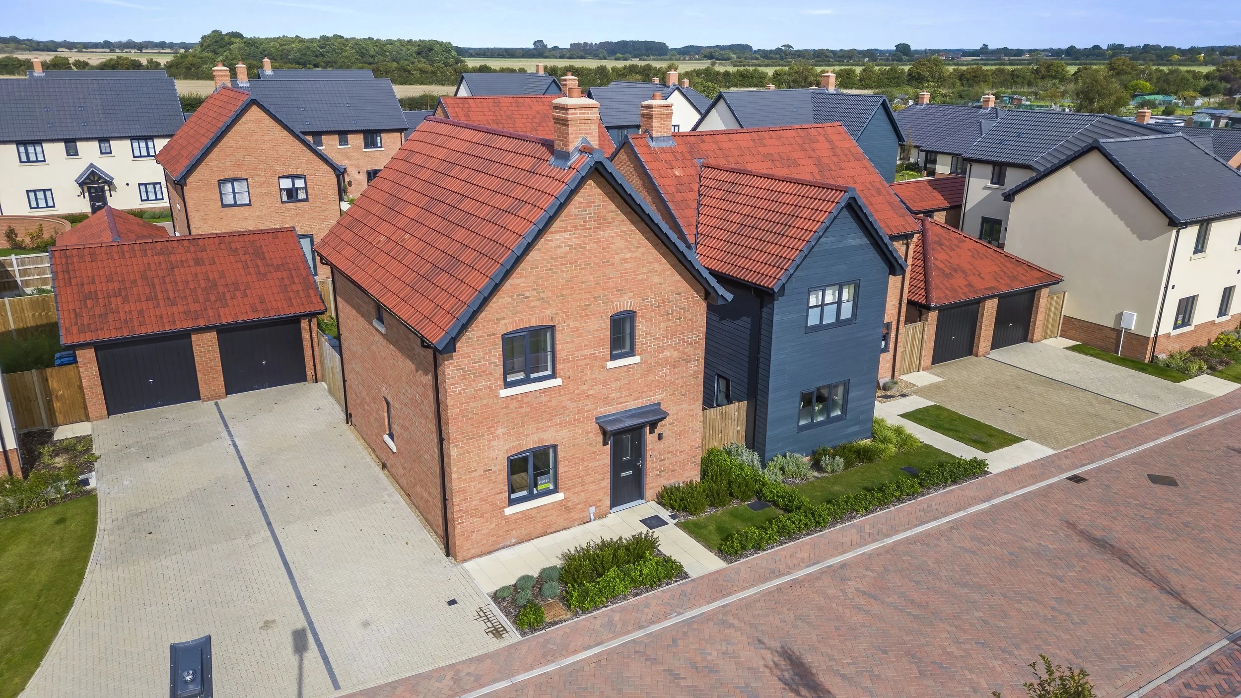 Red-brick and rendered homes with landscaped verges at The Lilacs