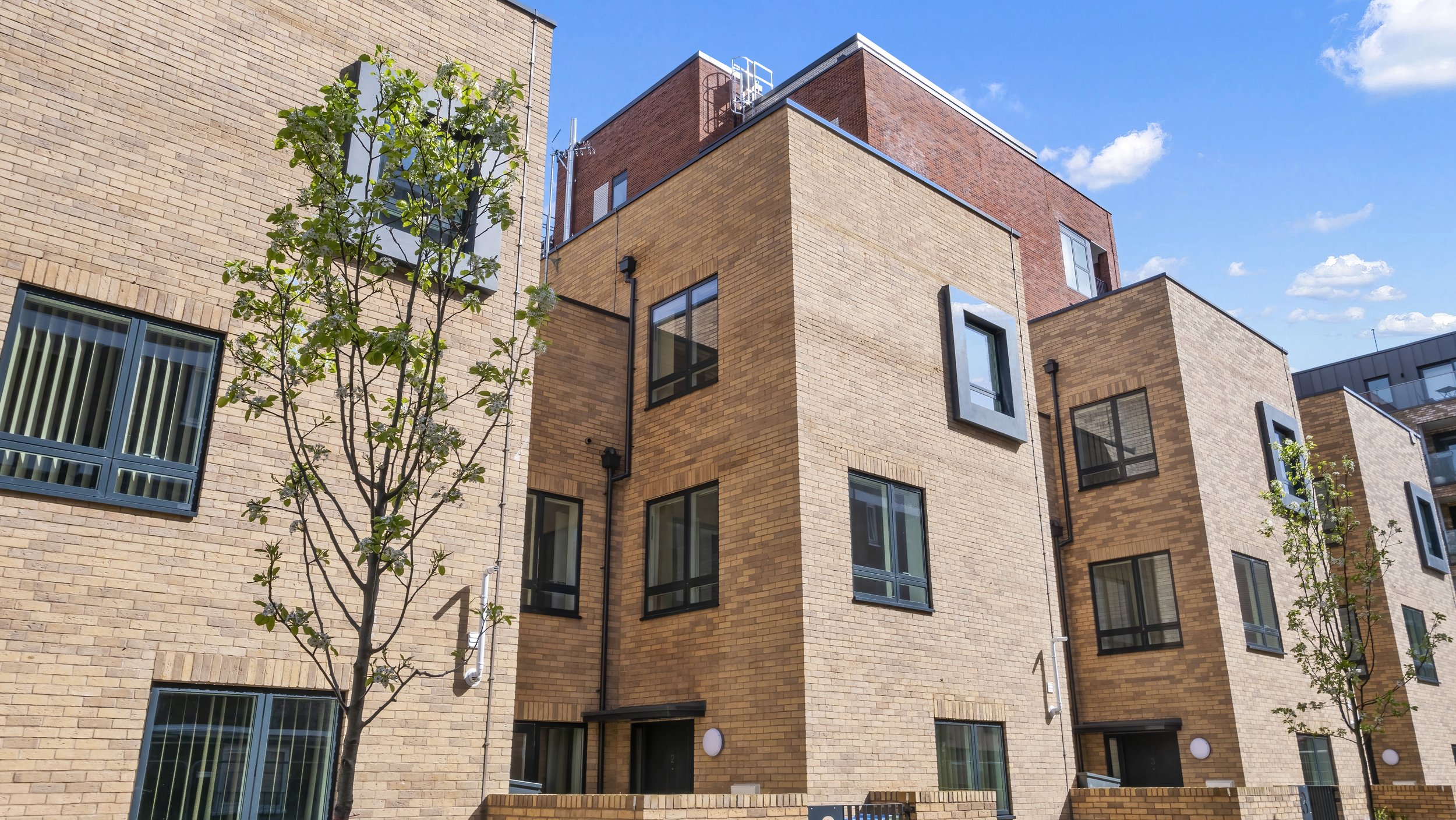 Brick apartment buildings and landscaped courtyard at Ivy Church Lane