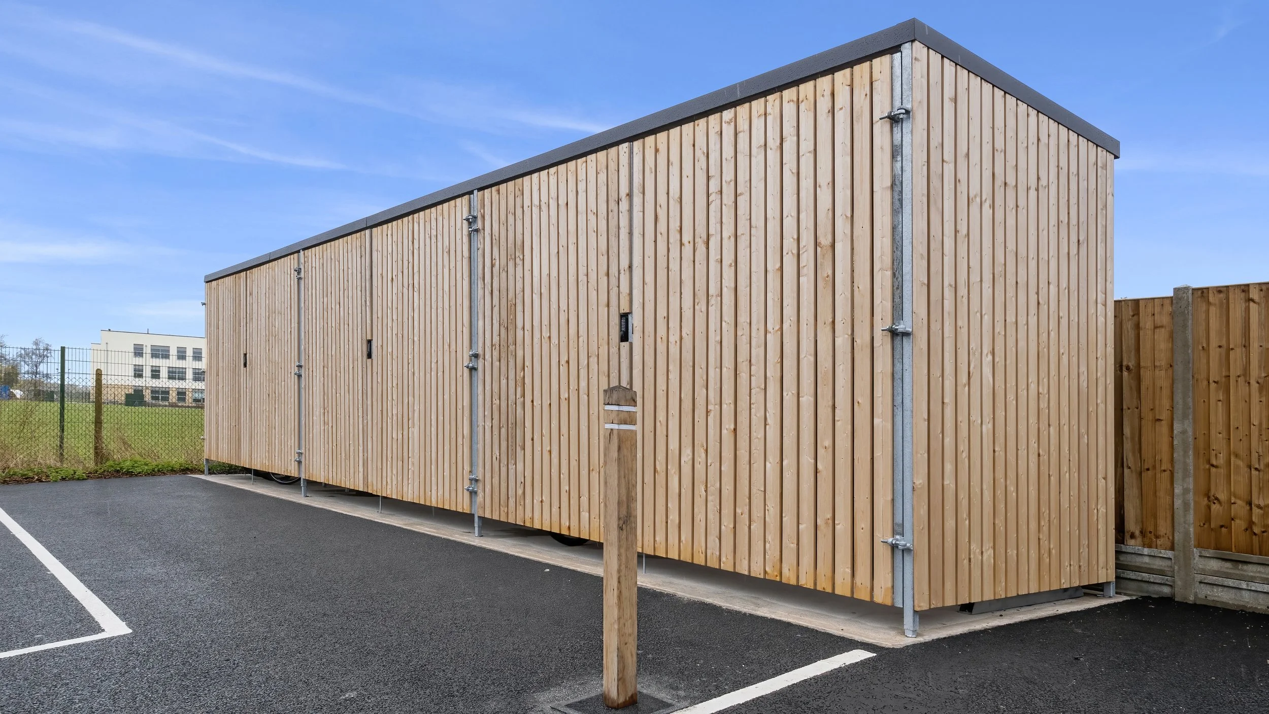 Timber-clad storage building beside parking at Wamil Court