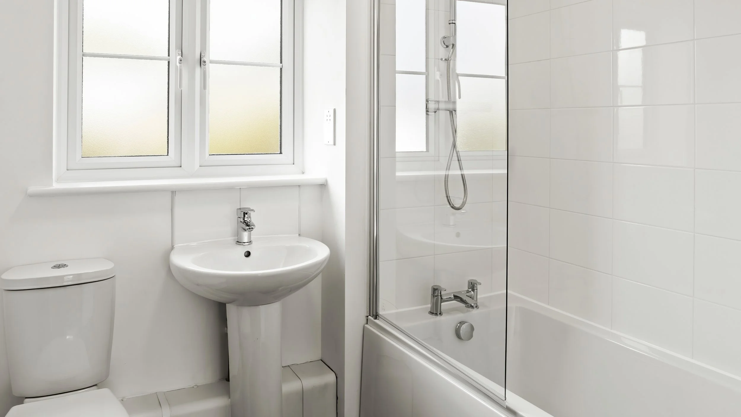 White bathroom with bath and shower at Great Staughton