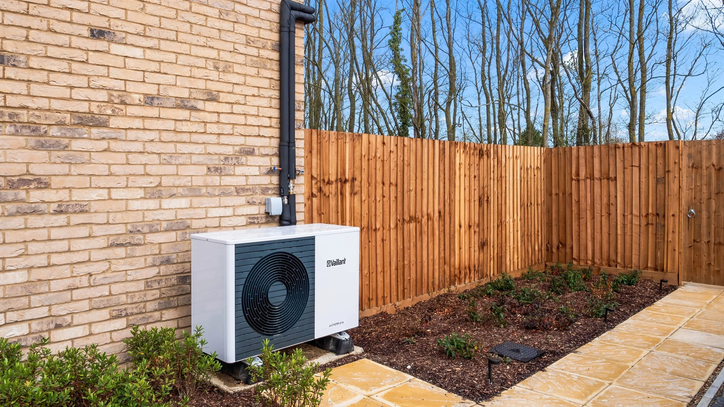 Air-source heat pump beside a brick home at Great Staughton