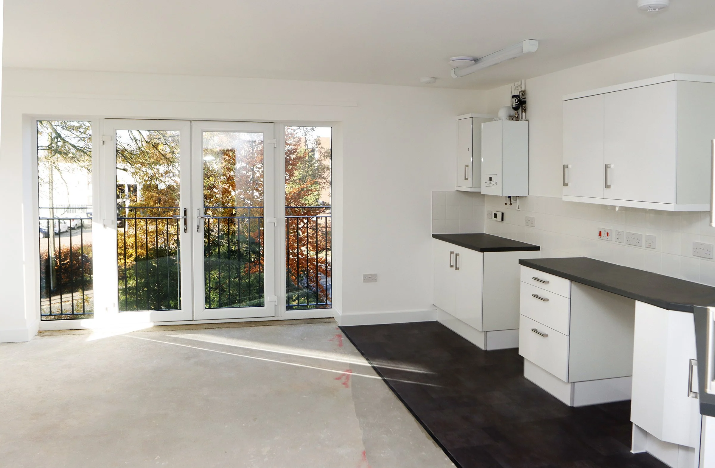 White kitchen and dining area with patio doors at Wade House