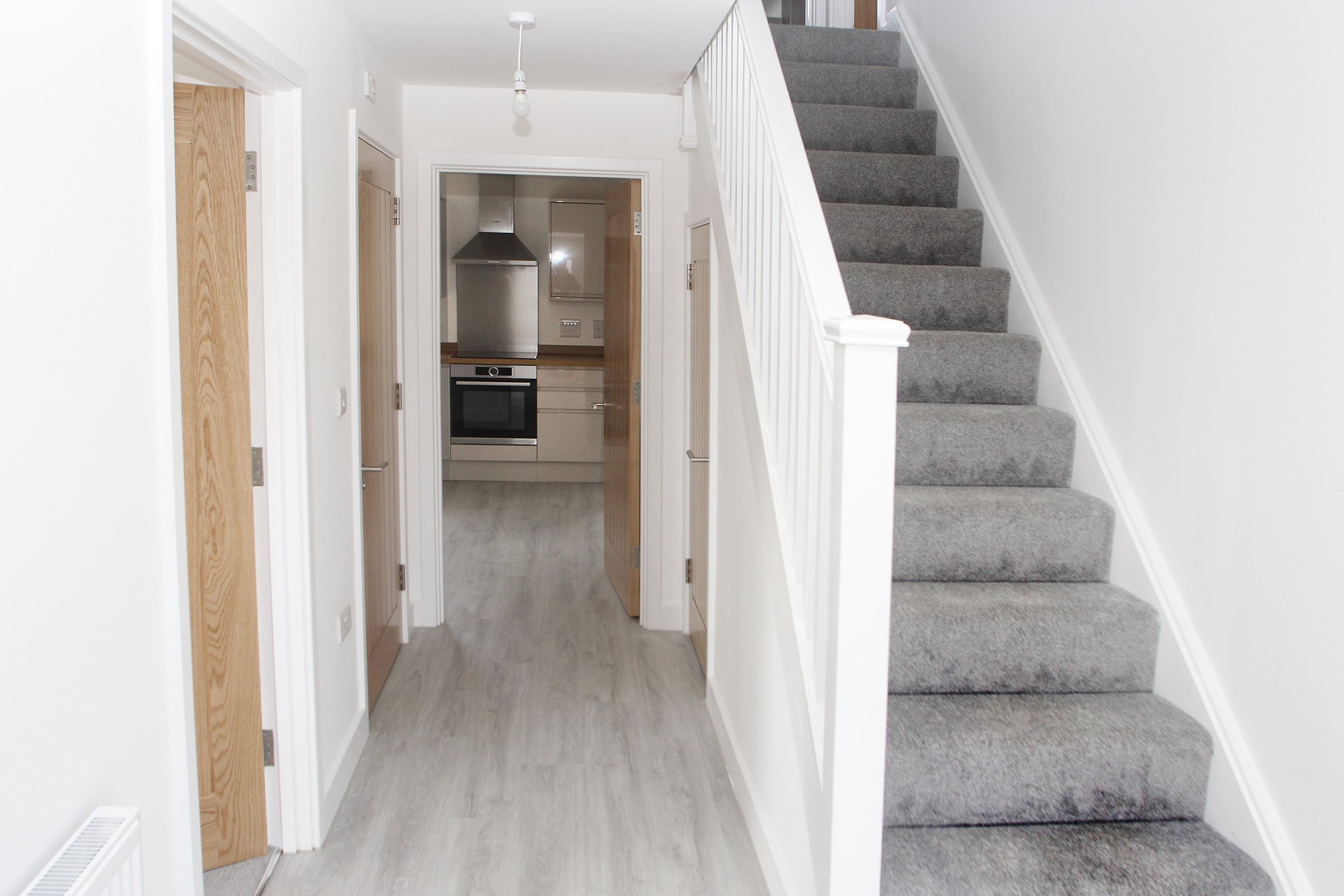 Hallway and carpeted staircase inside a Needingworth home